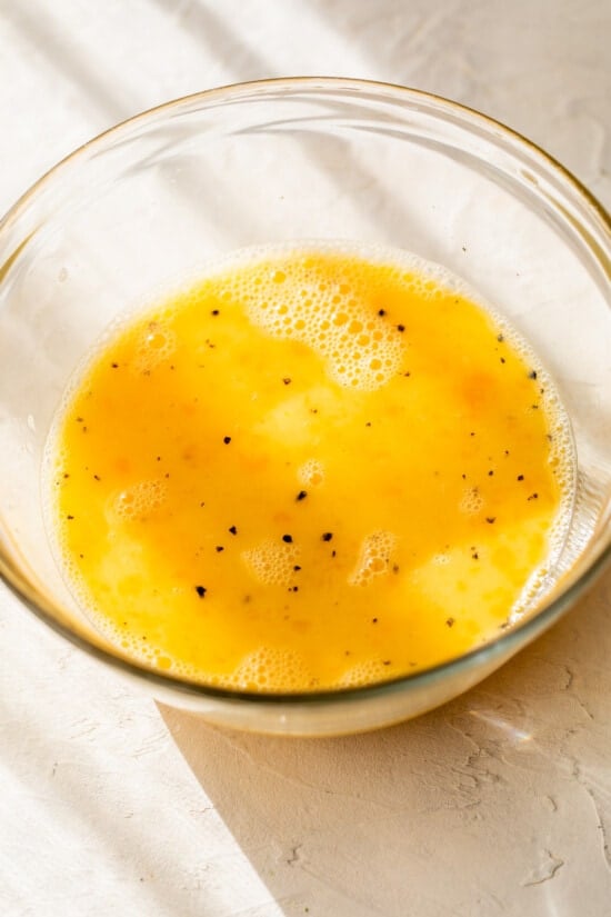 Eggs mixed with salt and pepper in bowl