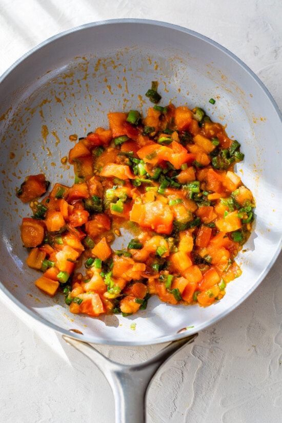 Tomatoes and scallions cooked in skillet
