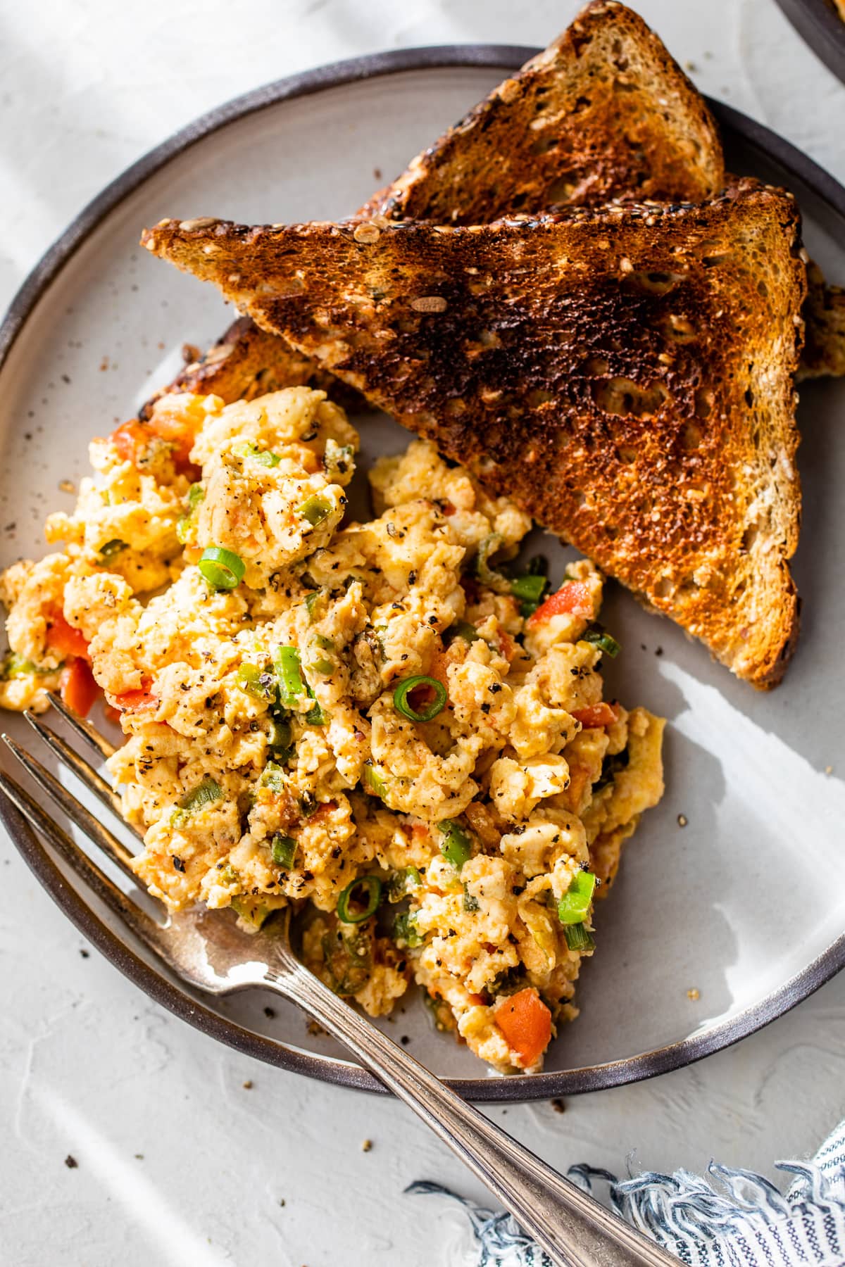 Huevos pericos on plate with two slices of toast and fork