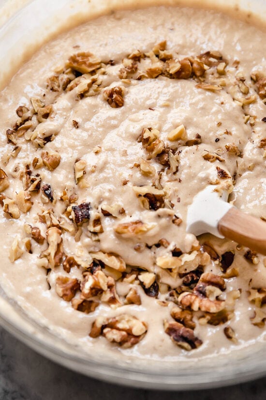 This delicious banana bread is be made with ripe mashed bananas, nuts, and spices. It's made healthier with less butter, oil and sugar. Banana Nut Bread batter in a bowl