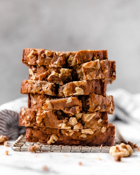 Slices of banana nut bread stacked on a wire rack.