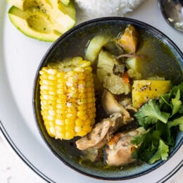 Bowl of Sancocho with rice and avocado