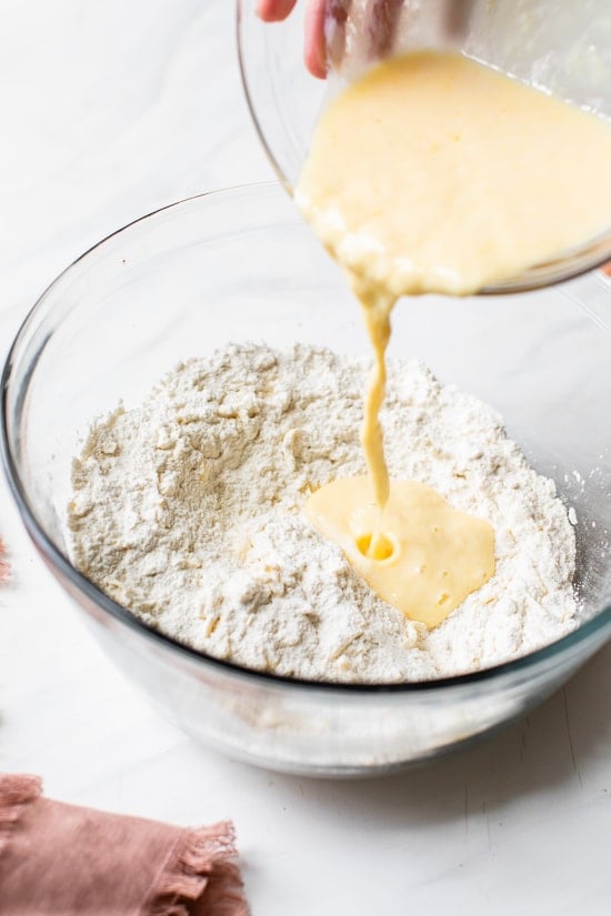 Pouring wet ingredients into dry ingredients to make scone batter.