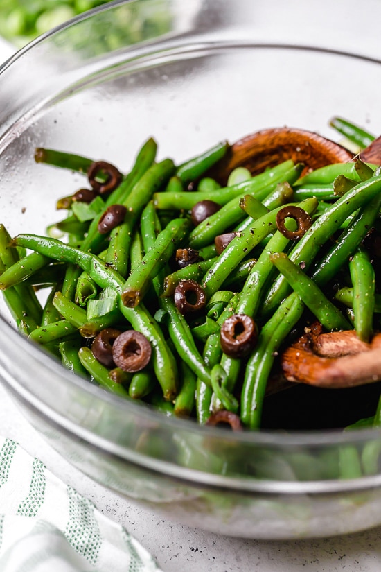 One of my favorite ways to enjoy green beans–in a chilled green bean salad recipe! The delicious flavors of these balsamic green beans made with black olives, scallions and eggs complement any meal or holiday potluck.