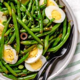 One of my favorite ways to enjoy green beans–in a chilled green bean salad recipe! The delicious flavors of these balsamic green beans made with black olives, scallions and eggs complement any meal or holiday potluck.