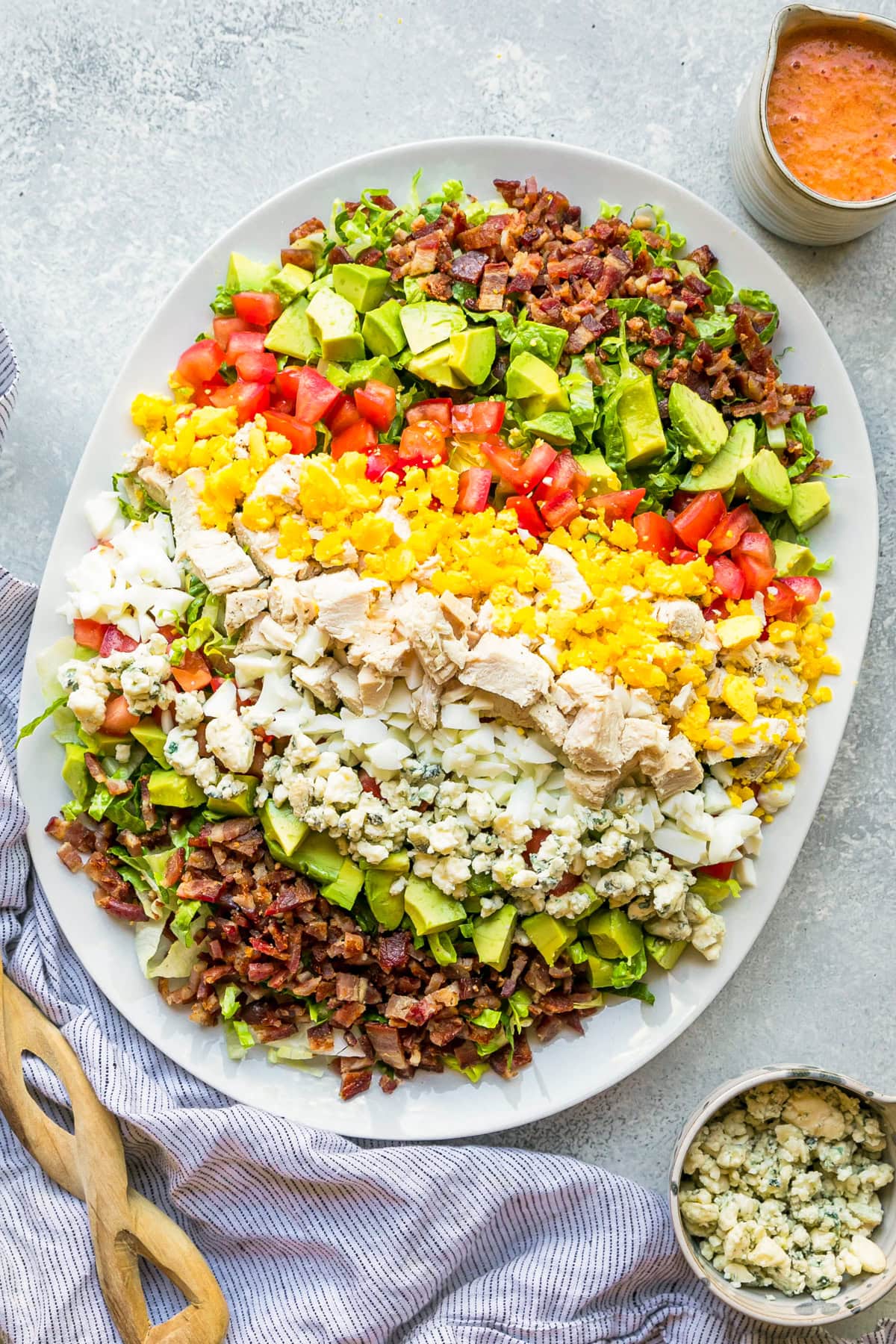 Layers of hard boiled eggs, bacon, blue cheese, tomatoes and avocado make up this classic Cobb salad recipe. It's the perfect lunch salad! Cobb salad with red wine tomato vinaigrette