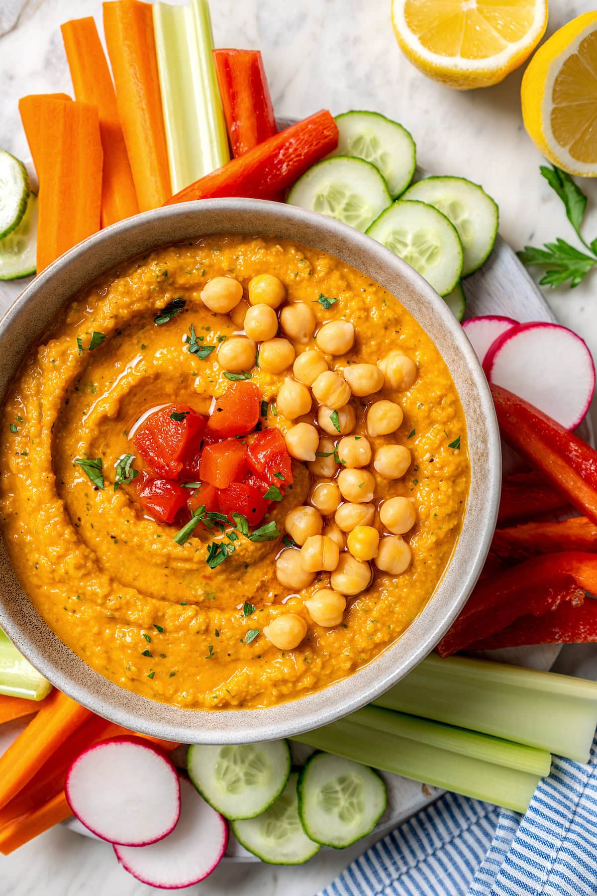 Smoky bell peppers add so much flavor to this roasted red pepper hummus recipe! Pair it with your favorite veggies for a healthy snack. Overhead view of homemade roasted red pepper hummus