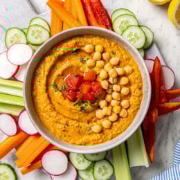 Overhead view of roasted red pepper hummus with fresh veggies