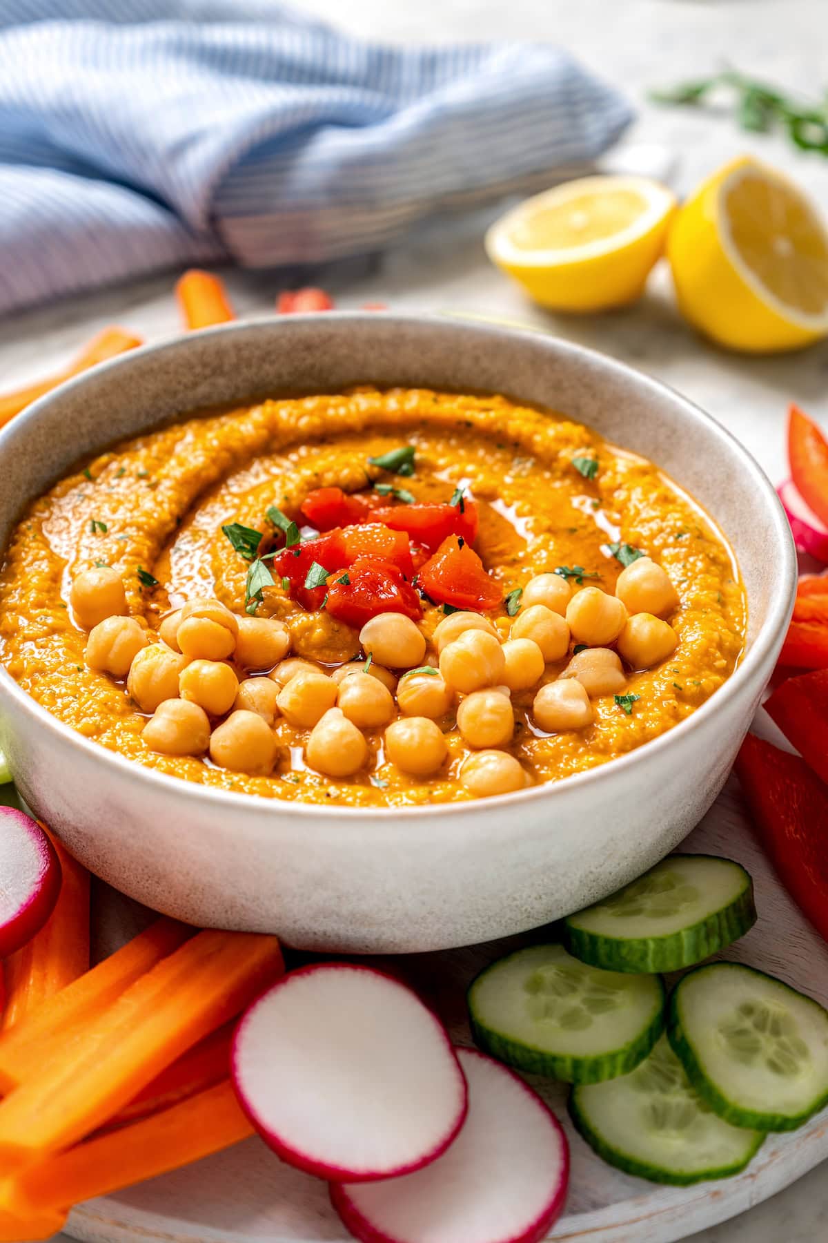 Bowl of roasted red bell pepper hummus garnished with peppers and chickpeas