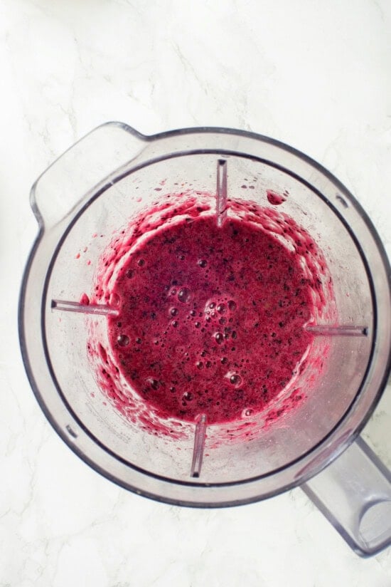 This easy blueberry compote recipe is a 3-ingredient fruit topping perfect for serving over ice cream, yogurt, and more. So summery! Overhead view of pureed blueberry mixture in blender