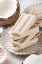 Four coconut popsicles stacked on plate