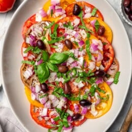 Overhead view of heirloom tomato salad with basil and kalamata olives