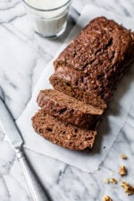 Sliced Chocolate Zucchini Bread loaf on white marble