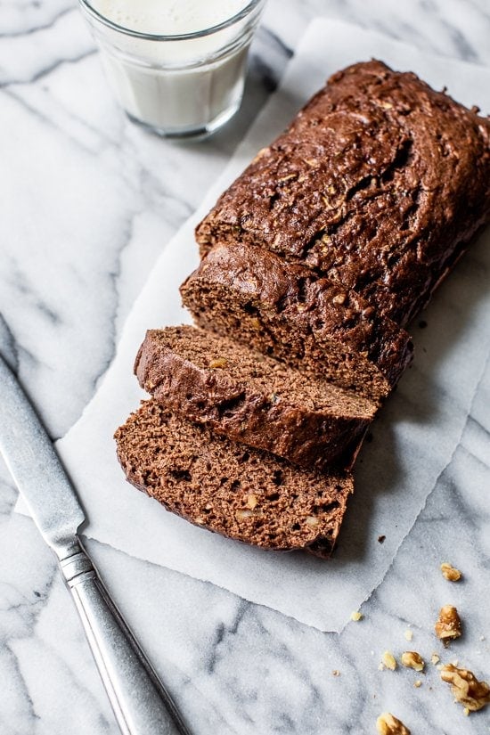Sliced Chocolate Zucchini Bread loaf on white marble
