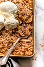 Golden brown apple crisp baked with oat topping and vanilla ice cream on top