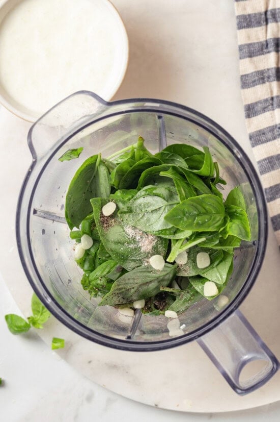 Basil green goddess dressing is the perfect way to give your next salad an upgrade! This version is lightened up, but still rich and creamy. Overhead view of ingredients for basil green goddess dressing added to blender