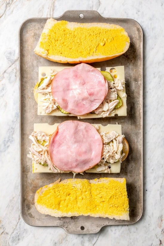 This turkey Cuban sandwich is an easy way to put those Thanksgiving leftovers to use, and my lightened up recipe won’t weigh you down either! Overhead view of Cuban turkey sandwiches being assembled