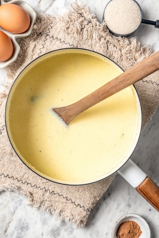 This easy lightened up homemade eggnog recipe comes together quickly and it’s so much tastier than store-bought. Creamy and delicious! Overhead view of homemade eggnog in pan