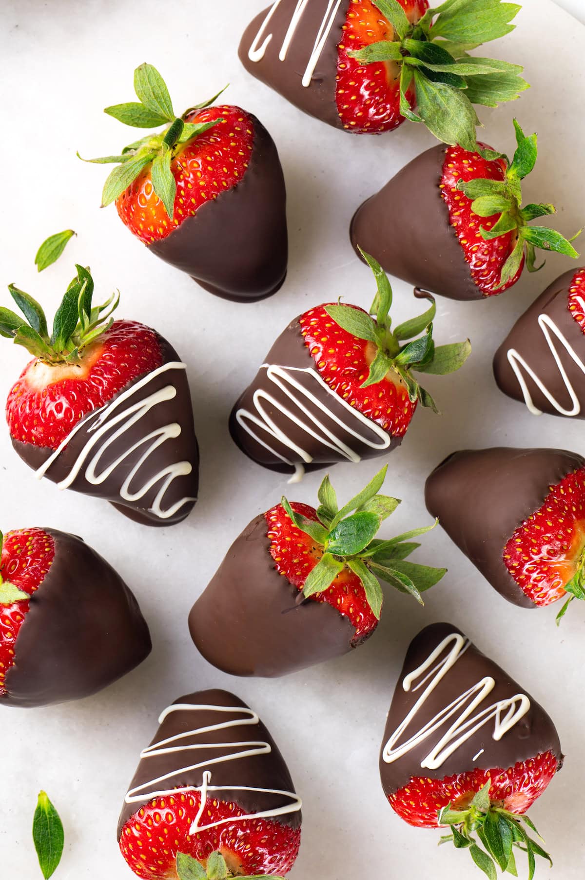 Chocolate-covered strawberries are an elegant treat that's incredibly easy to make at home. You'll never buy them at the store again! Overhead view of chocolate strawberries on countertop