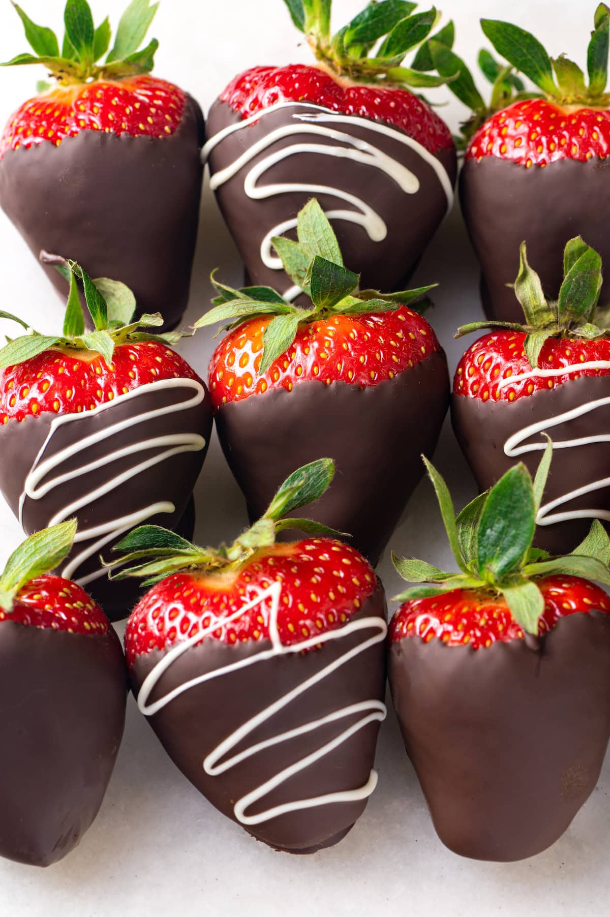 Chocolate-covered strawberries are an elegant treat that's incredibly easy to make at home. You'll never buy them at the store again! Chocolate-covered strawberries in three rows of three