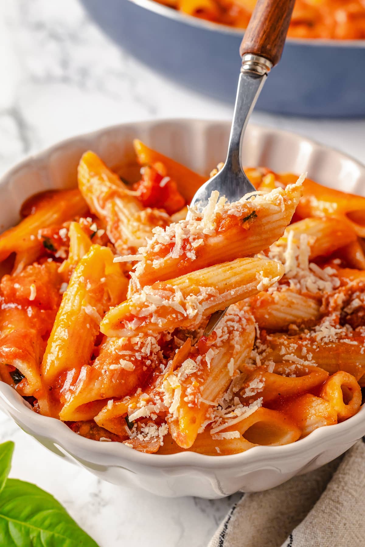 Penne alla Vodka is a simple yet showstopping pasta dish. The creamy tomato vodka sauce comes together in less than 30 minutes. A fork showing a bite of penne alla vodka over a bowl