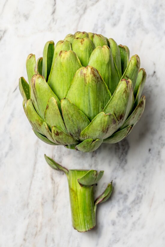 Stuffed artichokes are a classic Italian dish made with crispy, cheesy breadcrumbs. My version is a bit lighter but just as delicious! Overhead view of stem cut off of artichoke