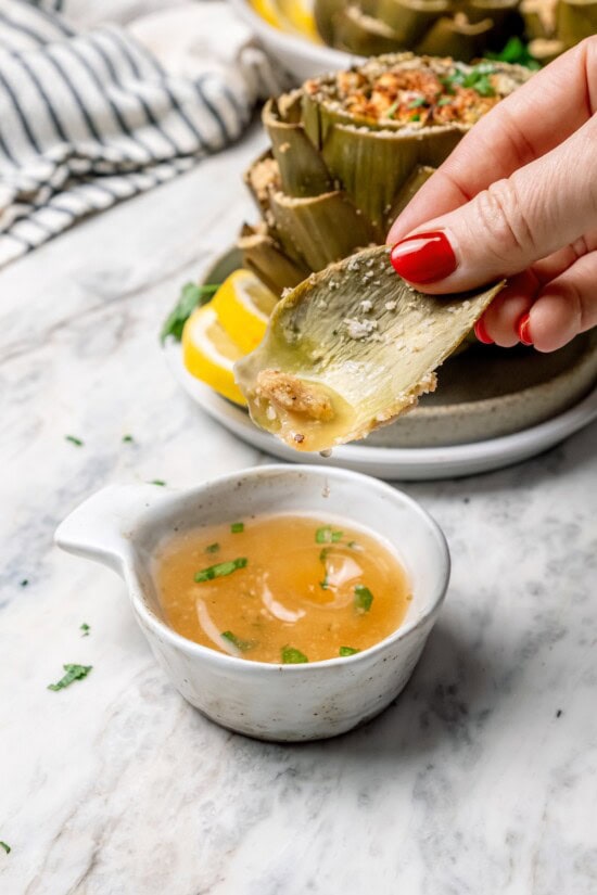 Stuffed artichokes are a classic Italian dish made with crispy, cheesy breadcrumbs. My version is a bit lighter but just as delicious! Dipping artichoke leaf into small cup of sauce