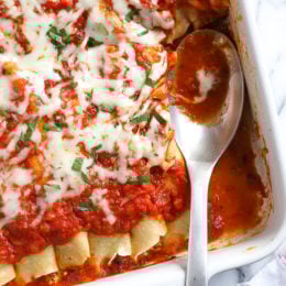 The secret to the best, irresistible manicotti is to make them from scratch with my easy homemade crespelles, which are basically Italian crepes. These spinach and cheese manicotti are filled with three cheeses – ricotta, mozzarella and parmesan, then topped with homemade sauce. So damn delicious!