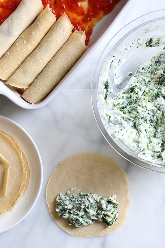 The secret to the best, irresistible manicotti is to make them from scratch with my easy homemade crespelles, which are basically Italian crepes. These spinach and cheese manicotti are filled with three cheeses – ricotta, mozzarella and parmesan, then topped with homemade sauce. So damn delicious!