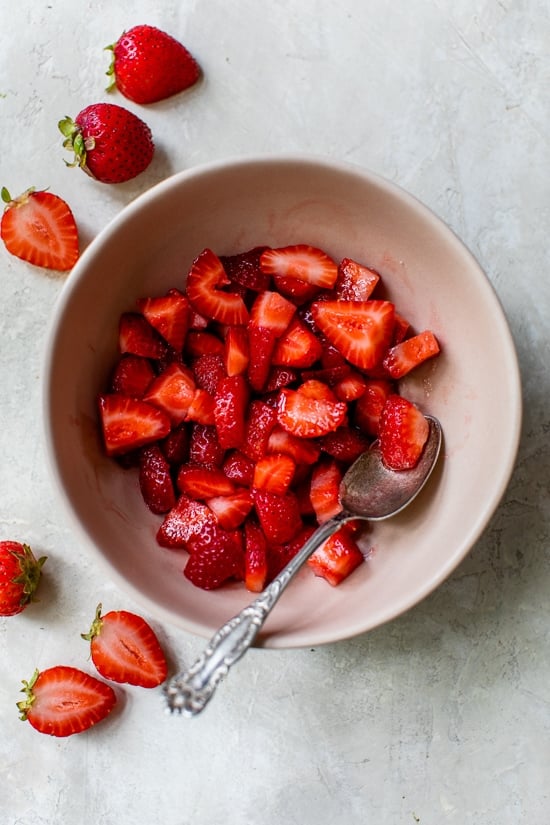 These simple strawberry scones made lighter are a wonderful breakfast and a delicious way to use up fresh summer strawberries! Strawberries mixed with sugar in a bowl.