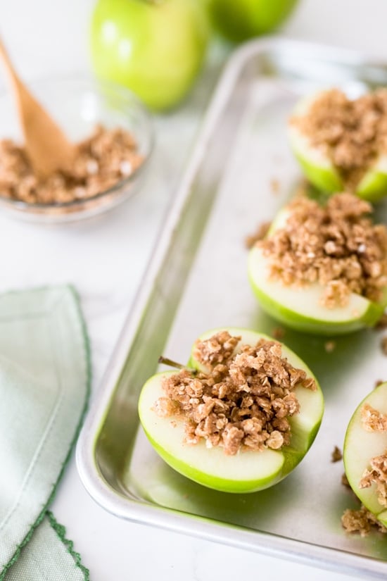 Baked apples topped with oats, cinnamon and a touch of brown sugar. Easy to make and a great way to use up those apples this Fall! They are like little individual apple crisps without all the added fuss of cutting and peeling the apples. A simple, light dessert for a cool autumn evening, serve this a la mode for an extra special treat!
