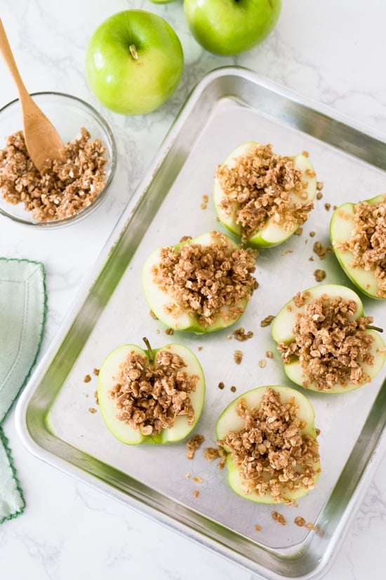 Baked apples topped with oats, cinnamon and a touch of brown sugar. Easy to make and a great way to use up those apples this Fall! They are like little individual apple crisps without all the added fuss of cutting and peeling the apples. A simple, light dessert for a cool autumn evening, serve this a la mode for an extra special treat!