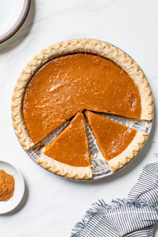 Still looking for the perfect Thanksgiving dessert? This easy, healthier version of the classic sweet potato pie recipe is always a hit! Overhead view of sweet potato pie with two slices cut