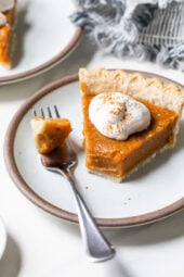 Sweet potato pie slice on plate, with tip on fork
