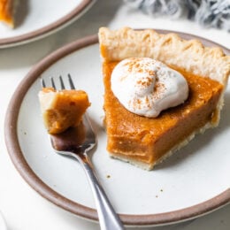 Sweet potato pie slice on plate, with tip on fork
