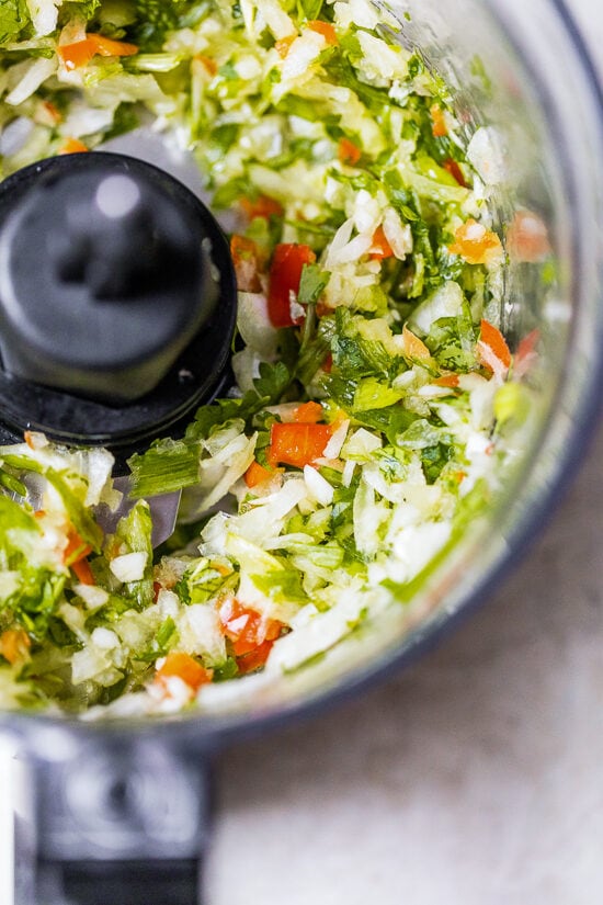 Authentic Arroz Con Pollo, or Latin chicken and rice, is the ultimate one-pot meal. It’s a classic Latin dish that I grew up with and love! Blended sofrito inside the food processor.