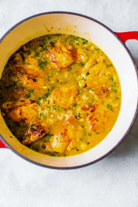 Authentic Arroz Con Pollo, or Latin chicken and rice, is the ultimate one-pot meal. It’s a classic Latin dish that I grew up with and love! Chicken and rice simmering in broth in a large pot.