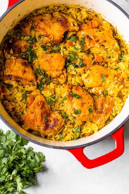 Overhead view of Arroz Con Pollo in a red Dutch oven.