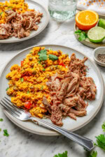 Slow cooker pernil on plate with rice