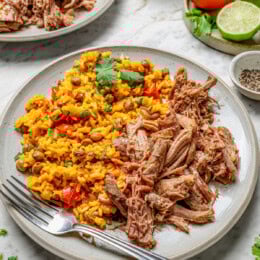 Slow cooker pernil on plate with rice
