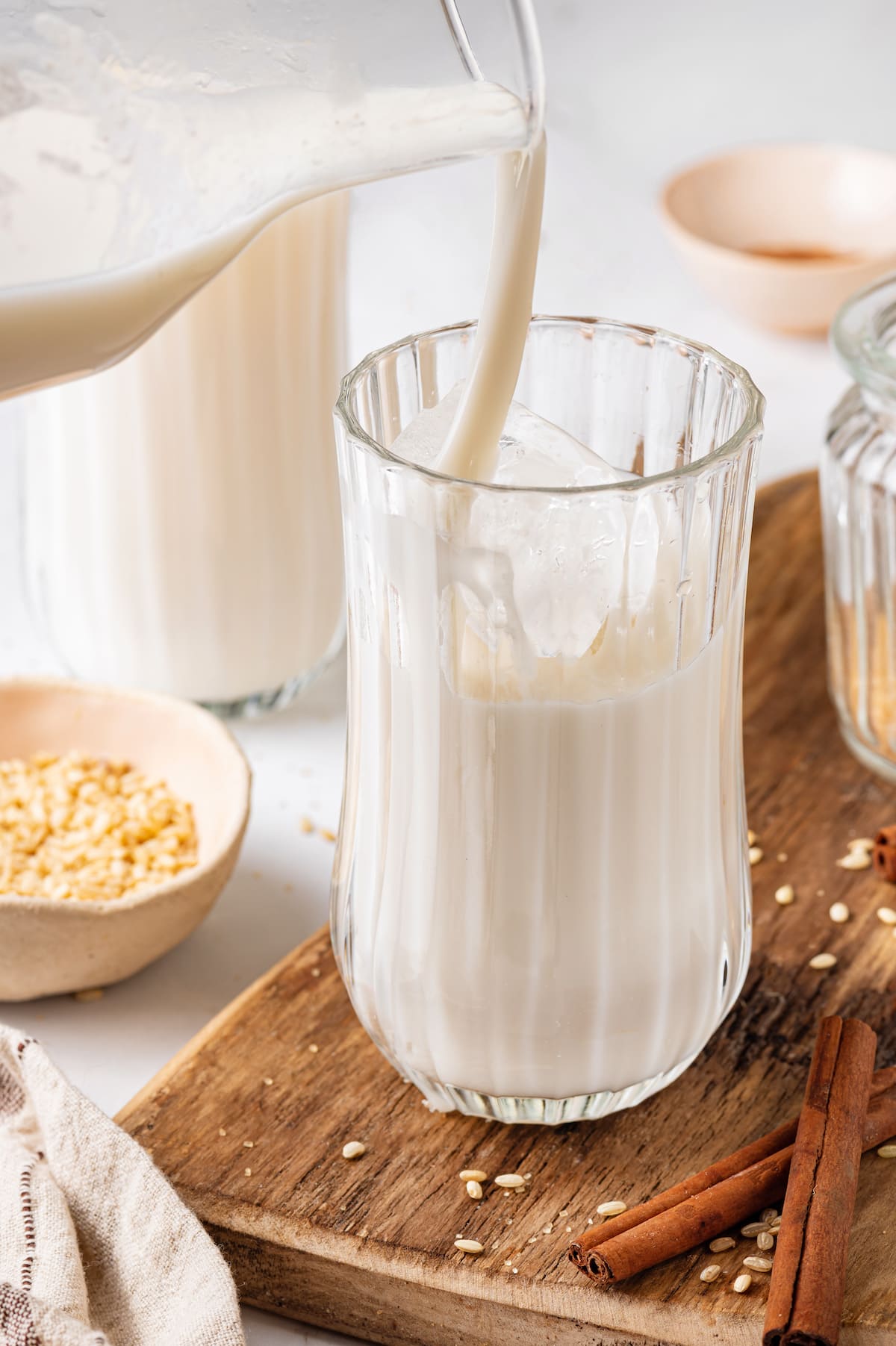Made with brown rice, milk, sugar, and cinnamon served over ice, this Easy Horchata recipe makes a delightfully refreshing drink for hot days. Horchata being poured into a glass