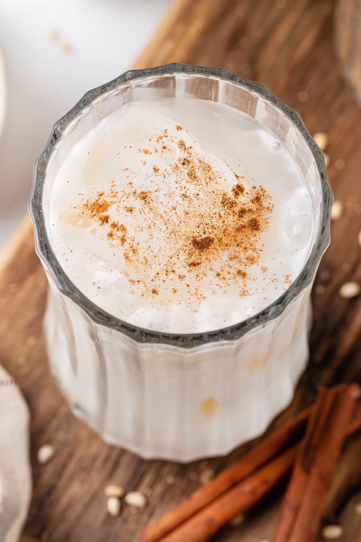 Made with brown rice, milk, sugar, and cinnamon served over ice, this Easy Horchata recipe makes a delightfully refreshing drink for hot days. Angled overhead view of a glass of horchata