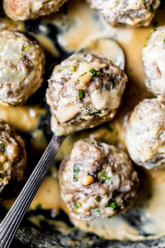 These easy Swedish meatballs are a lighter version of the classic, but they have the same cozy, comforting flavor and creaminess you love! Swedish meatball in spoon with creamy gravy.