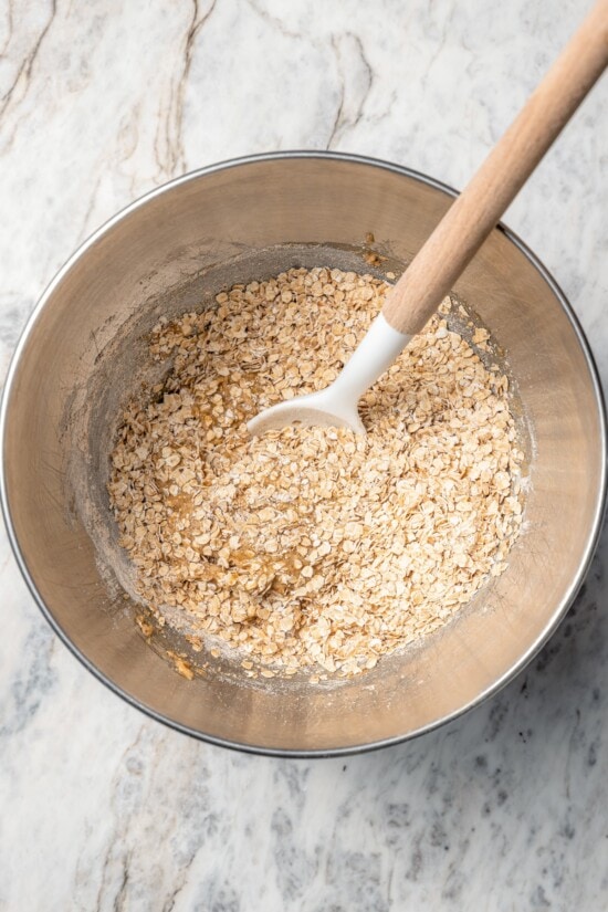 Chewy granola bars are so easy to make at home! This recipe is lighter than other versions and can be customized with your favorite mix-ins. Stirring dry ingredients in bowl for granola bars.