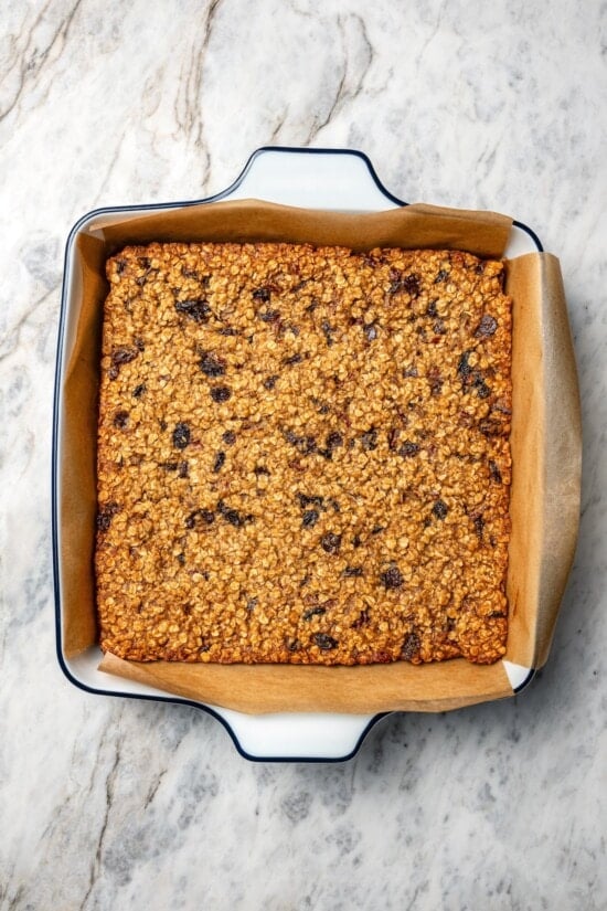 Chewy granola bars are so easy to make at home! This recipe is lighter than other versions and can be customized with your favorite mix-ins. Chewy granola bars in pan before slicing.