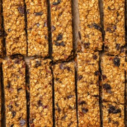Sliced chewy granola bars on parchment paper.