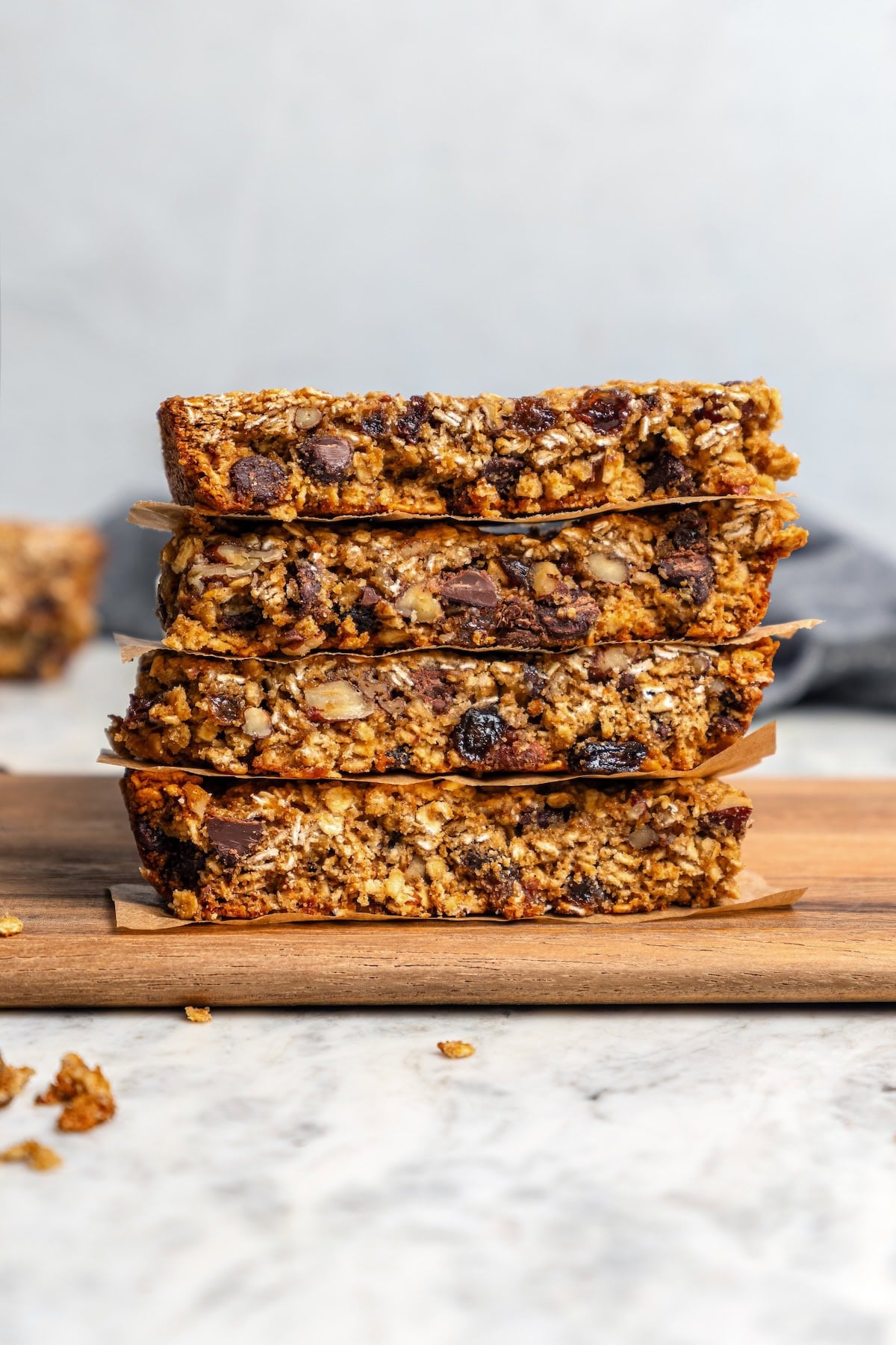 Stack of 4 chewy granola bars with chocolate chips, pecans, and raisins.