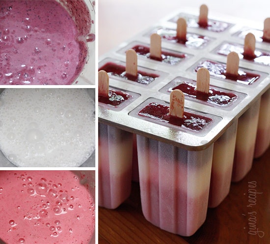 Three bowls with different colors of liquid berry mixture and a set of popsicle molds with striped berry popsicles