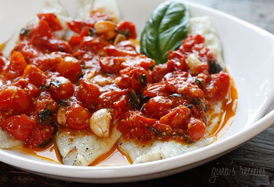 A bowl with broiled fish fillets topped with grape tomato sauce