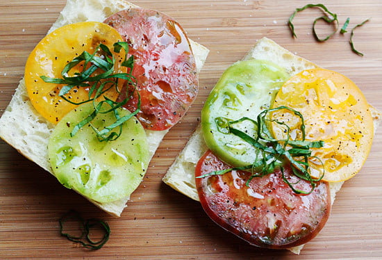 A juicy open faced summer tomato sandwich on crusty bread drizzled with extra virgin olive oil, a chiffonade of fresh basil, salt and fresh ground pepper. Simplicity at it's best!